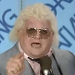 Dusty Rhodes speaking into a microphone during a televised wrestling interview